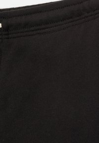 Tissu noir, matériau extensible, texture lisse, finition douce, doté d'une taille simple et d'arêtes nettes sans motifs ni embellissements.