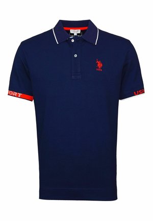 Polo bleu marine avec bordure blanche au col, logo USPA rouge sur la poitrine, texte rouge et blanc sur les poignets des manches, et patte de boutonnage à deux boutons.