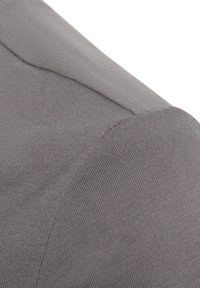 Grijze katoenstof met een gladde textuur, met een naaddetail langs de schouder en een lichte curve aan de rand van de mouw.