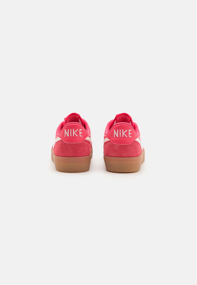 Zapatillas de ante rosa con suela de goma. En la parte trasera muestra el logo "NIKE" en blanco. Cuenta con un cuello acolchado y una franja lateral blanca en contraste.