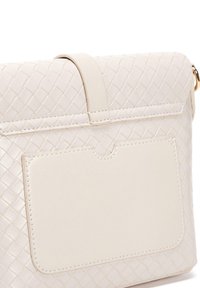 Borsa in pelle intrecciata di colore beige chiaro con una patch rettangolare, texture liscia, bordi morbidi e dettagli di cucitura delicati. Include una tracolla superiore.