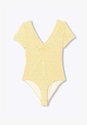 Body jaune à manches courtes avec petit imprimé floral blanc, encolure en V et léger détail froncé au niveau de la poitrine.