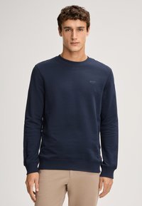 Sweatshirt blu navy realizzato in tessuto morbido, con scollatura a girocollo e polsini a coste. Dettaglio logo discreto sul petto, vestibilità comoda.