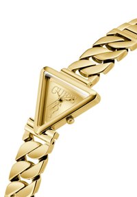 Gold-toned triangular watch with a glossy face featuring the "GUESS" logo and a question mark, complemented by a chunky chain bracelet.