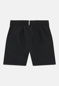 Juodi šortai su elastiniu diržu, pagaminti iš lengvos medžiagos. Lygus paviršius, laisvas prigludimas, be papildomų aksesuarų ar kišenių.