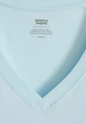T-shirt Levi's bleu clair à col en V avec étiquette imprimée indiquant la taille S/P/CH et "Fabriqué au Bangladesh" en trois langues.