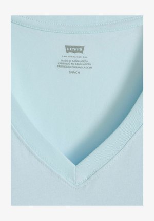 T-shirt Levi's bleu clair à col en V avec étiquette imprimée indiquant la taille S/P/CH et "Fabriqué au Bangladesh" en trois langues.