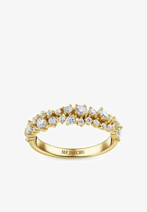 Gylden ring med flere runde og ovale klare ædelsten sat langs båndet. Har en glat overflade og "SIF JAKOBS" indgraveret indvendigt.