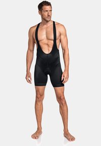 Schwarze Radsport-Bib-Shorts für Herren mit ärmellosem Design, strukturiertem Stoff und tiefem Ausschnitt. Mit gepolstertem Sitz für zusätzlichen Komfort.
