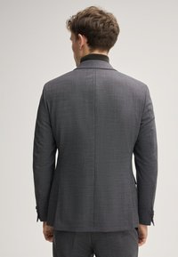 Grau strukturierte Anzugjacke mit taillierter Passform, Schößchen und Knopf-Details. Die Rückansicht zeigt saubere Linien und eine strukturierte Silhouette.