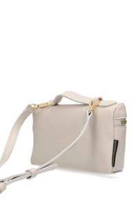 Petit sac bandoulière en cuir beige texturé avec des accessoires en ton or et une bandoulière ajustable sur fond blanc.
