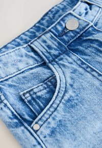 Jeans in denim azzurro chiaro con una finitura sbiadita, dotati di una tasca frontale, rivetto in metallo e cuciture a contrasto lungo le cuciture.