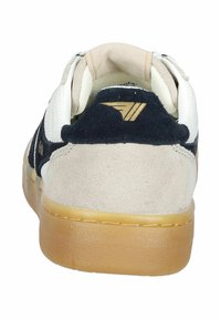 Multikleurige sneaker met een marineblauwe leren hiel, beige bovenkant en een contrasterende gumrubberen zool. Bevat een logo-detail nabij de hiel.