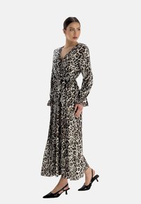 Leopardenmuster Wickelkleid mit langen Ärmeln, einem gebundenen Taillenband und einem fließenden Rock. Verfügt über einen tiefen V-Ausschnitt und eine weiche, seidige Textur.