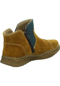 Braune Wildleder-Stiefelette mit einem strukturierten blauen Stoffpanel. Verfügt über einen seitlichen Reißverschluss und eine flexible Gummisohle mit einem gemusterten Profil.