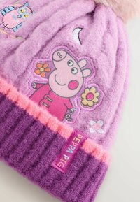Lila gestrickte Mütze mit rosa Akzenten, die Peppa Wutz und Blumenstickerei zeigt. Weicher Stoff, gerippter Rand und ein Markenlabel.
