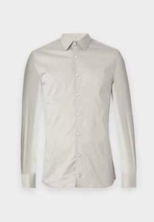 Lichtgrijze langsl sleeve shirt gemaakt van een gladde stof. Heeft een puntige kraag, knopen aan de voorkant en een getailleerde pasvorm met een minimalistisch ontwerp.