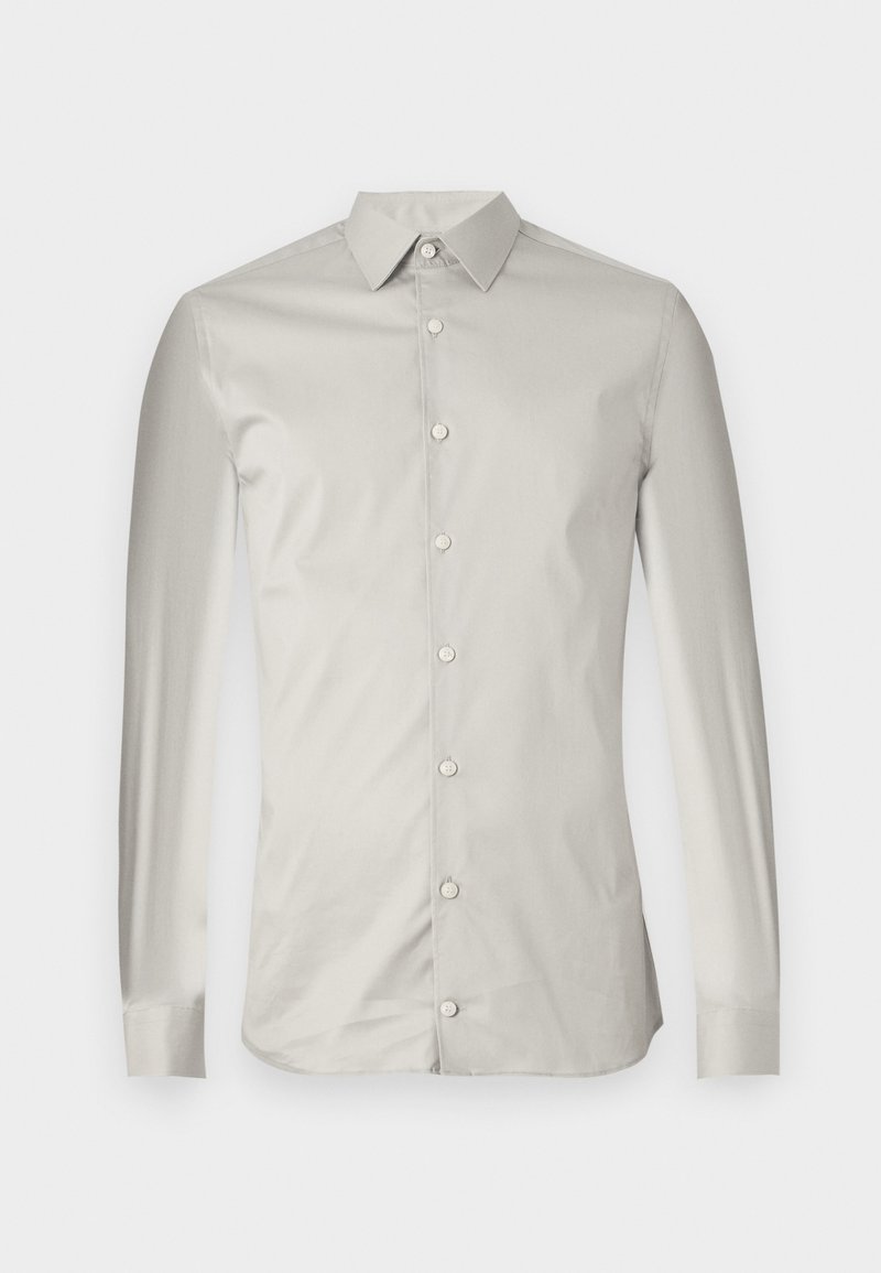 Chemise à manches longues gris clair en tissu lisse. Présente un col pointu, des boutons sur le devant et une coupe ajustée avec un design minimal.