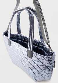 Λαμπερό ασημί τσάντα με σχέδιο καπιτονέ, δύο επενδεδυμένες λαβές και αποσπώμενο ιμάντα ώμου με το λογότυπο της μάρκας.