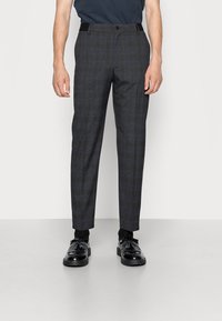 Grå rutiga byxor gjorda av ett strukturerat tyg, med en rak ben-design, framfickor och en polerad finish. Bärs tillsammans med svarta skor.