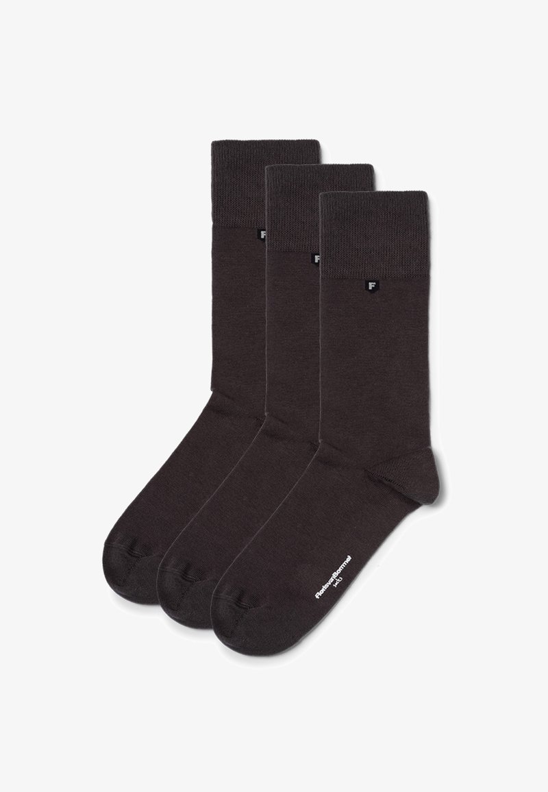 Trois paires de chaussettes en mélange de coton marron foncé avec des bords côtelés, des talons renforcés et un marquage minimaliste près du bord, présentant une texture unie.