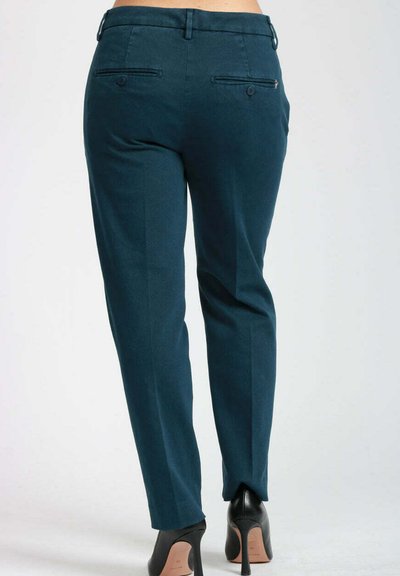 Pantaloni tailored in teal con vestibilità slim, dotati di tasche posteriori, chiusura con zip e una texture del tessuto liscia. Indossati con tacchi alti neri.