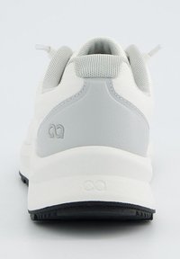 Weiße Sportschuhe mit einer strukturierten Oberseite, grauem Fersenbereich und schwarzem Gummiaußensohle; minimalistisches Design mit subtilen Logodetails.