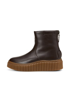 Bruine leren enkellaars met een ronde neus, een ritsluiting en een geprofileerde, beige plateauzool met verticale groeven.