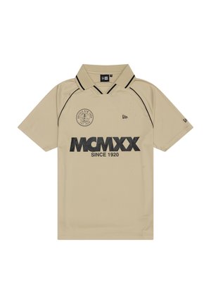 Polo beige à manches courtes avec bordure noire, texte "MCMXX Since 1920", logo rond sur la poitrine, et petits logos de la marque sur la poitrine et la manche.