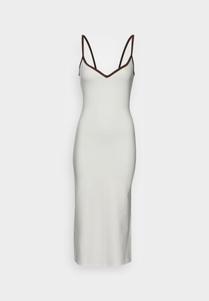 Robe nuisette midi blanche avec fines bretelles noires et bordure noire le long de l'encolure sur fond uni.
