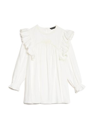 Hvid bluse med lange ærmer, prydet med flæsedetaljer og rund halsudskæring. Har teksturerede detaljer og rynket stof ved brystet.