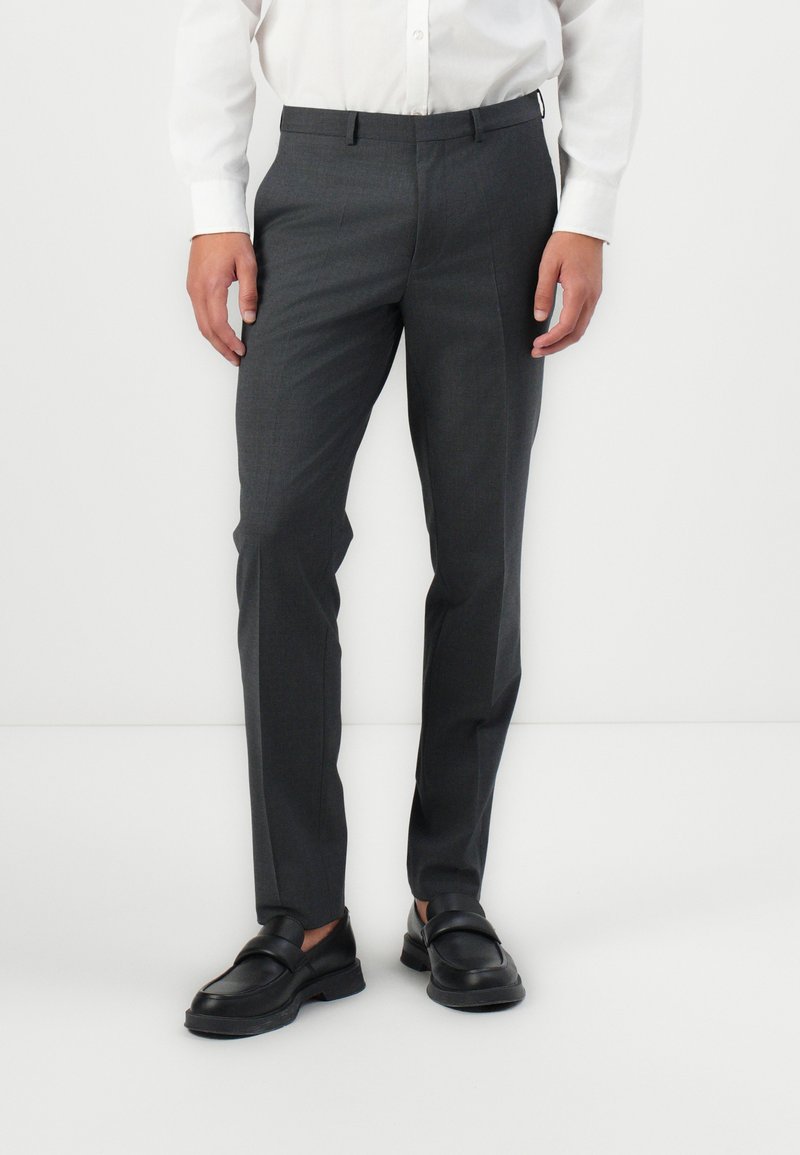 Grå skreddersydde bukser med en jevn tekstur, rette ben og flat frontdesign. Brukes med en hvit skjorte og svarte loafers.