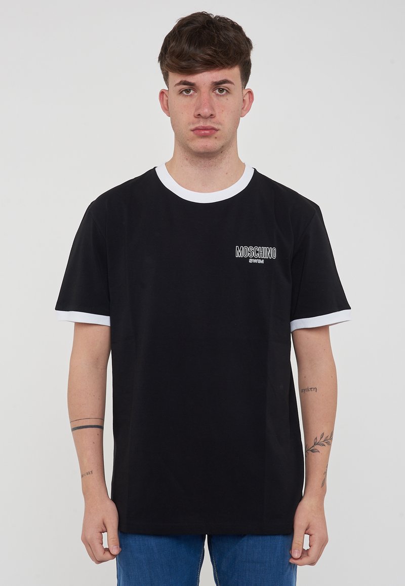 T-shirt in cotone nero con colletto rotondo bianco e maniche corte. Presenta il logo "Moschino" in bianco sulla parte alta a sinistra.