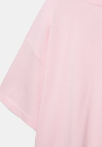 Svetloružová krátky rukávová košeľa s okrúhlym výstrihom a výrazným detalom švov na rukávoch a ramenách.