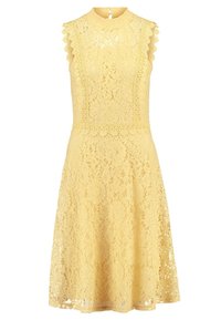 Krajkové šaty v jasně žluté barvě, s vysokým výstřihem, vroubkovanými okraji a rozevlátou sukní. Květinové vzory po celém oblečení, strukturovaná látka.
