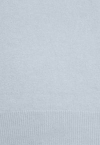 Suéter azul claro hecho de tela de punto suave, con una textura lisa y dobladillo acanalado, que ofrece un diseño simple y limpio.