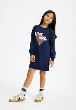 Navy blue sweatshirt dress with long sleeves, featuring a colorful "LOVE WINS" graphic. Paired with white sneakers and striped socks.