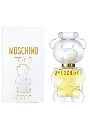 Moschino Toy 2 Eau de Parfum avec flacon de 50 ml en forme d'ourson transparent tenant un parfum jaune, à côté d'une boîte blanche avec inscriptions dorées.