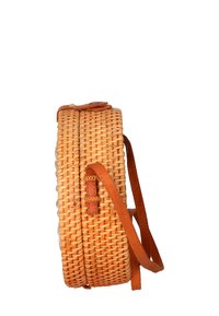Borsa a cestino tonda intrecciata in paglia naturale con dettagli in pelle marrone chiaro. Presenta una base piatta, una tracolla regolabile e una chiusura superiore con un bottone.