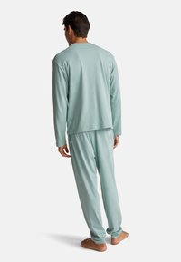 Hellblaue, langärmelige Schlafanzug-Set aus weicher Stoff; entspannte Passform mit Hose und elastischem Bund, einfaches Design ohne Muster oder Akzente.