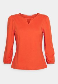 Orange long-sleeve top made of soft fabric, featuring a round neckline with a small cutout and puffed sleeves with elastic cuffs.