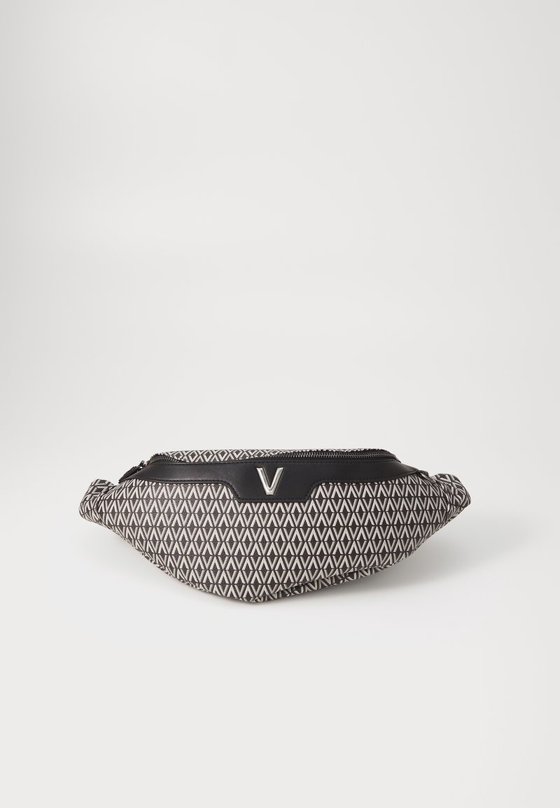 Svartvitt handväska med geometriskt mönster och rundad form, utrustad med en svart dragkedja och en metallisk "V"-detalj på framsidan.