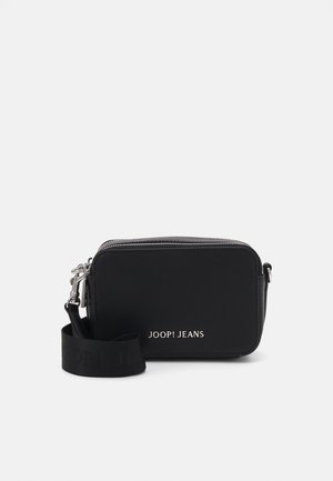 Black shoulder bag made of textured material. Features a zip closure, a detachable strap with branding, and a rectangular shape.