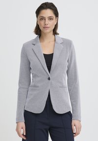 Blazer gris clair en tissu texturé, doté d'une coupe ajustée, de revers crantés, d'une fermeture à bouton unique et de deux poches avant.