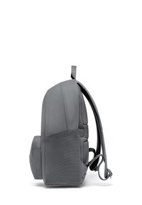 Grå ryggsäck med vadderade sidor, mimikande tyg, justerbara remmar och en sidoficka. Kompakt design, lämplig för vardagligt bruk.