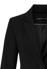 Černé sako s vykrojeným klopou, zavíráním na jeden knoflík a strukturovanou látkou. Má střih na míru a hladkou vnitřní podšívku.