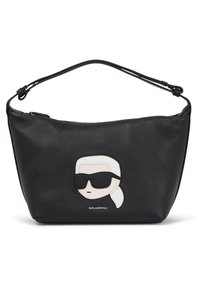 Sort læder skuldertaske med en struktureret overflade, der har en hvid og sort karakter-appliqué på forsiden, glat rem med hardware.