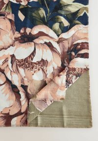 Coperta floreale con grandi peonie rosa su uno sfondo scuro, con lato verde e bordi frangiati. Tessuto morbido e.Texture.