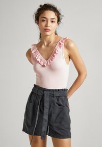 Top in rosa con scollatura arricciata e pantaloni corti grigio scuro con cintura, dotati di tasche laterali, vestibilità comoda e texture morbida.