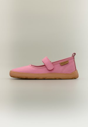 Chaussure Mary Jane rose avec une semelle marron et une bride Velcro, affichée de profil sur un fond beige uni.